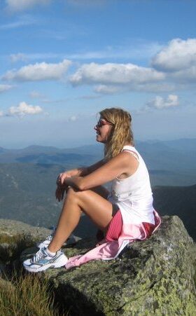 Jennifer Palladino meditating on mountain top.