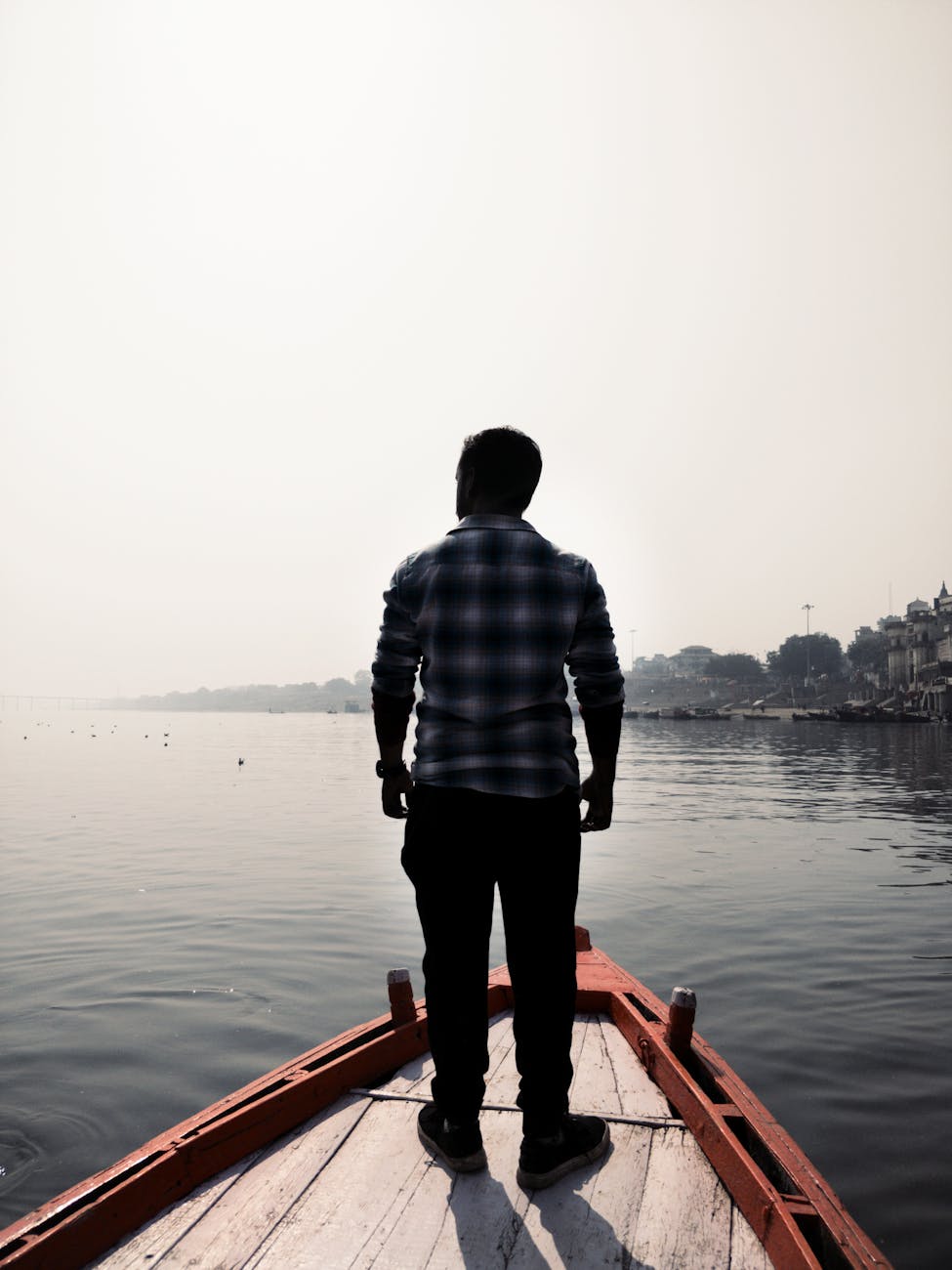 man standing on wooden boat
